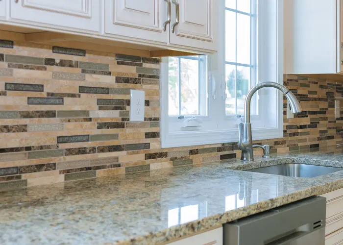 Gorgeous earth toned kitchen backsplash consisting of various shades of brown, tan, and grey